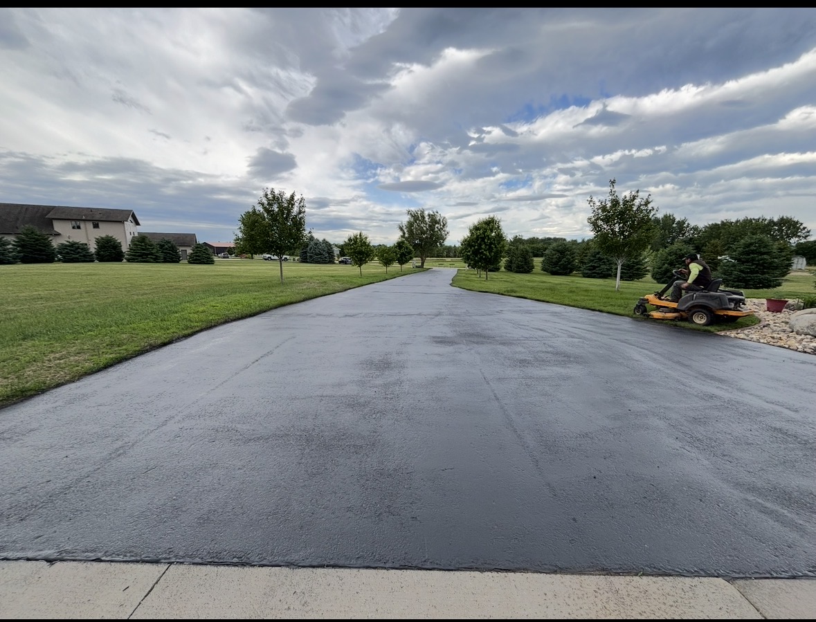 Long residential driveway freshly sealed with deep black finish